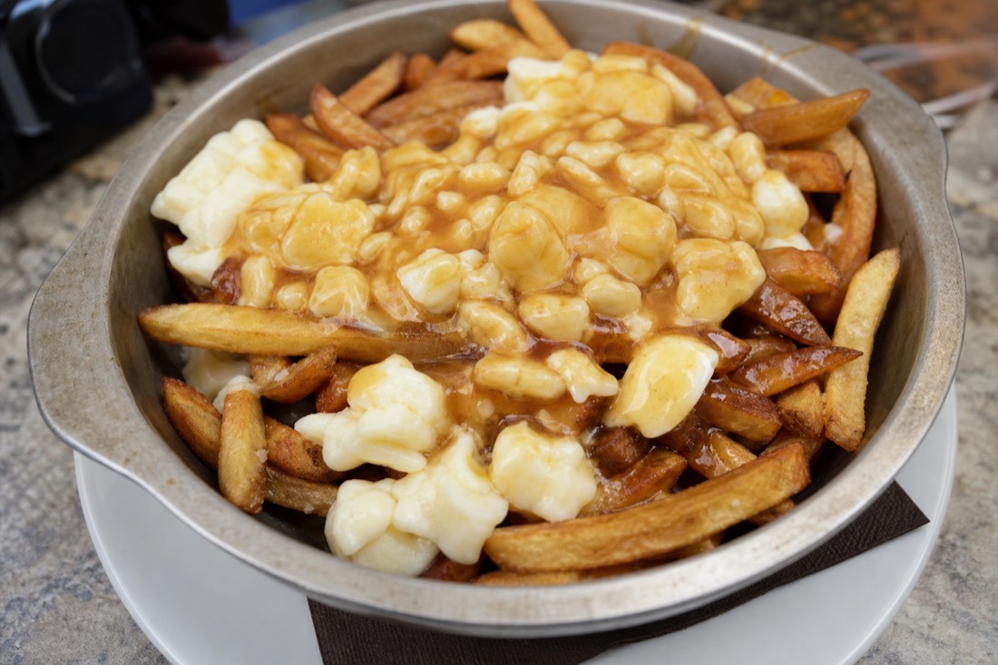 Close-up of classic Quebec poutine with cheese curds melting into hot brown gravy