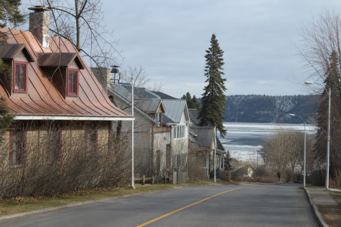 Street in Wendake, the Huron-Wendat Nation community near Quebec City, with houses and the Saint-Charles river beyond