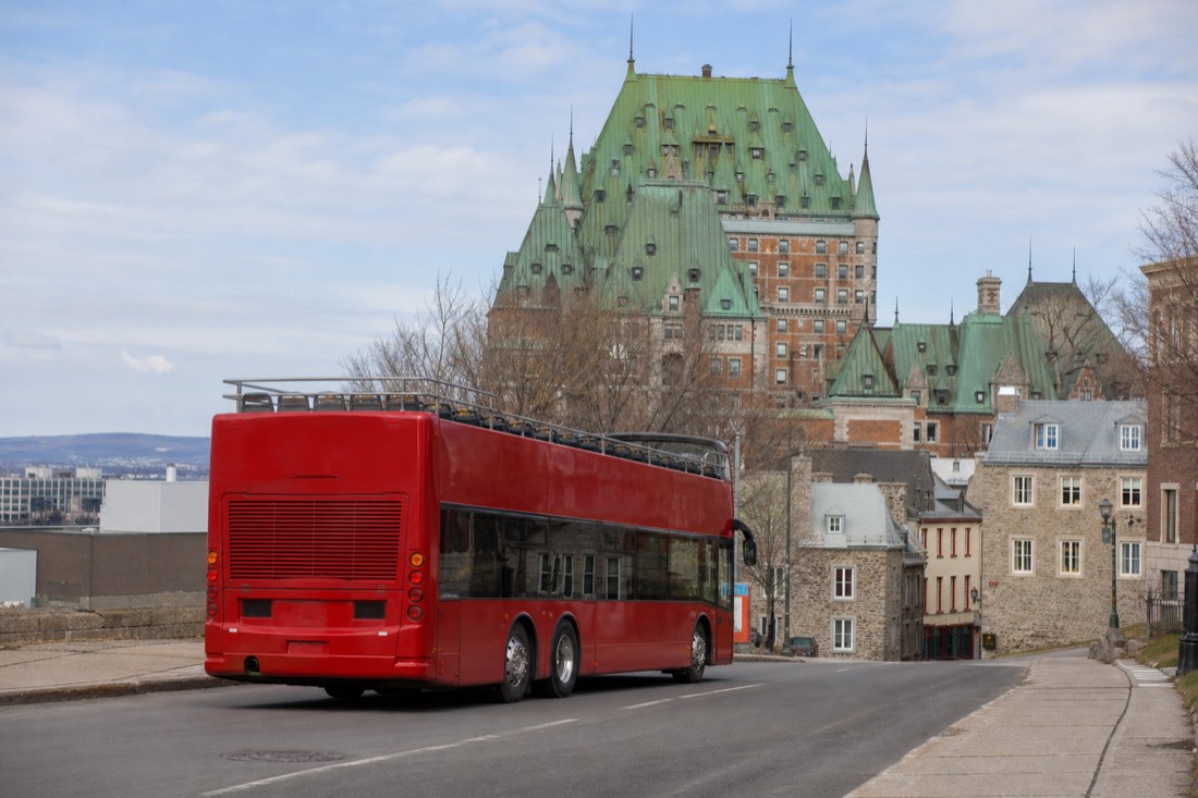Open-top double-decker sightseeing bus on a Quebec City street, a city loop that does not serve Wendake
