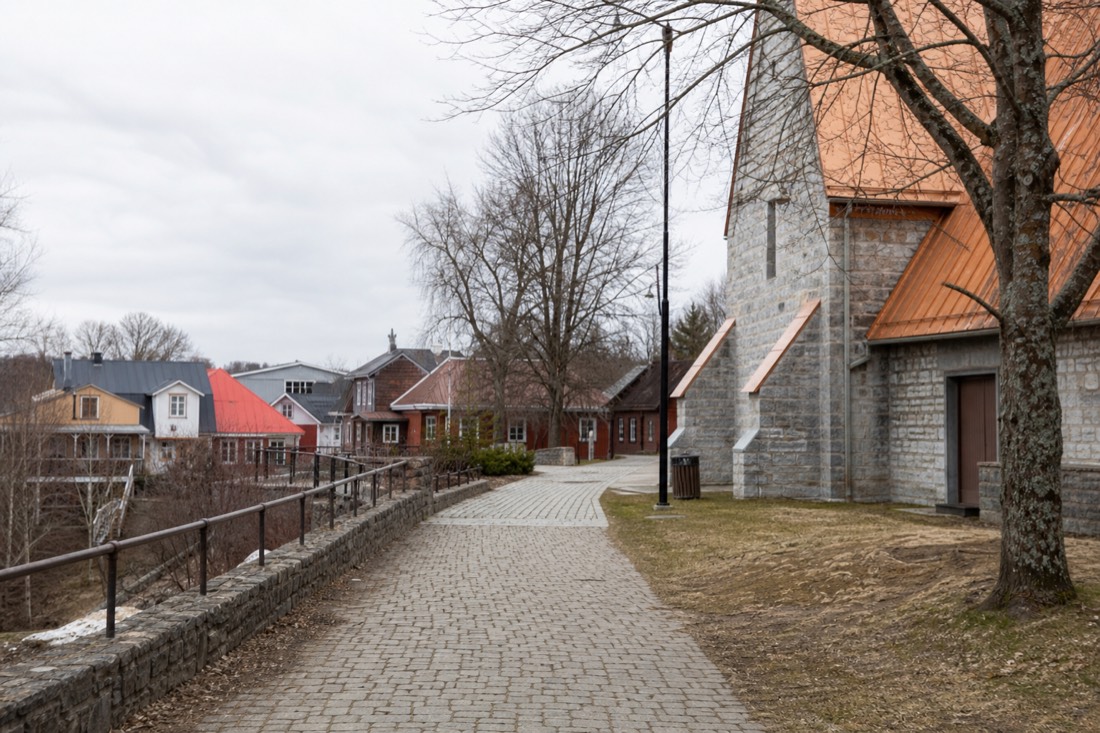 Visitors walking a public path in Wendake past community buildings near the Saint-Charles river