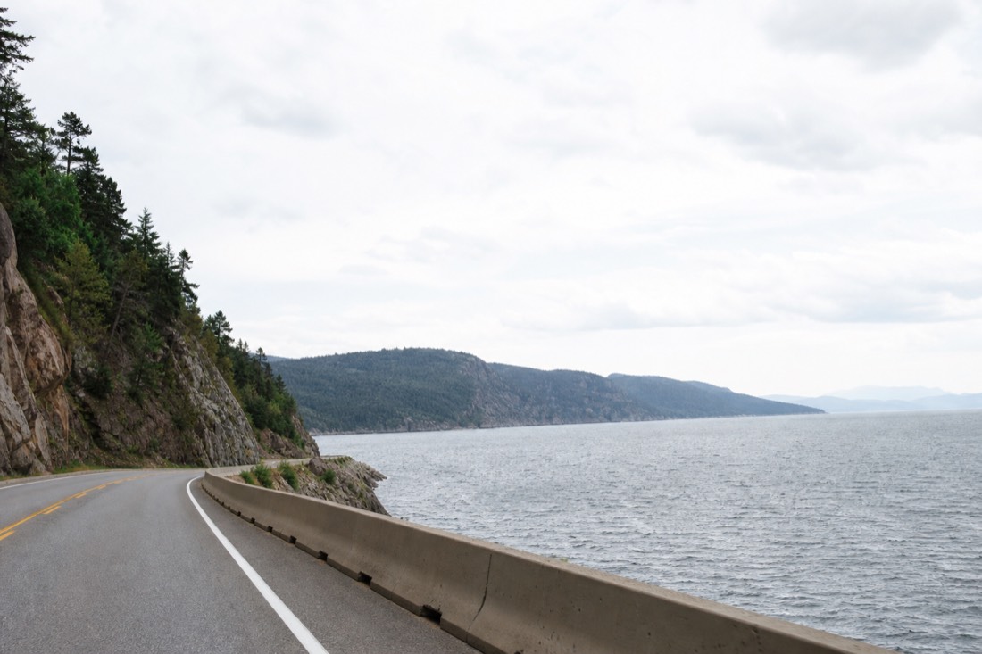 Route 138 running east along the Beaupré coast toward Canyon Sainte-Anne with the St. Lawrence River alongside