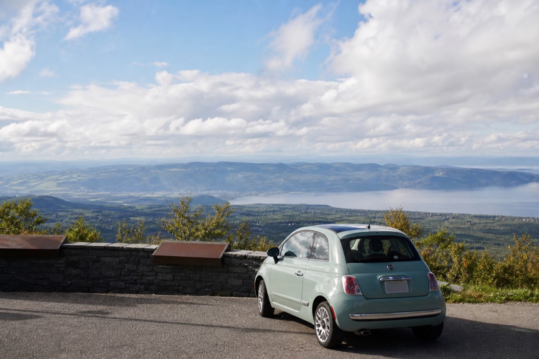 Small car parked at a roadside lookout over the Charlevoix valley on a day trip from Quebec City