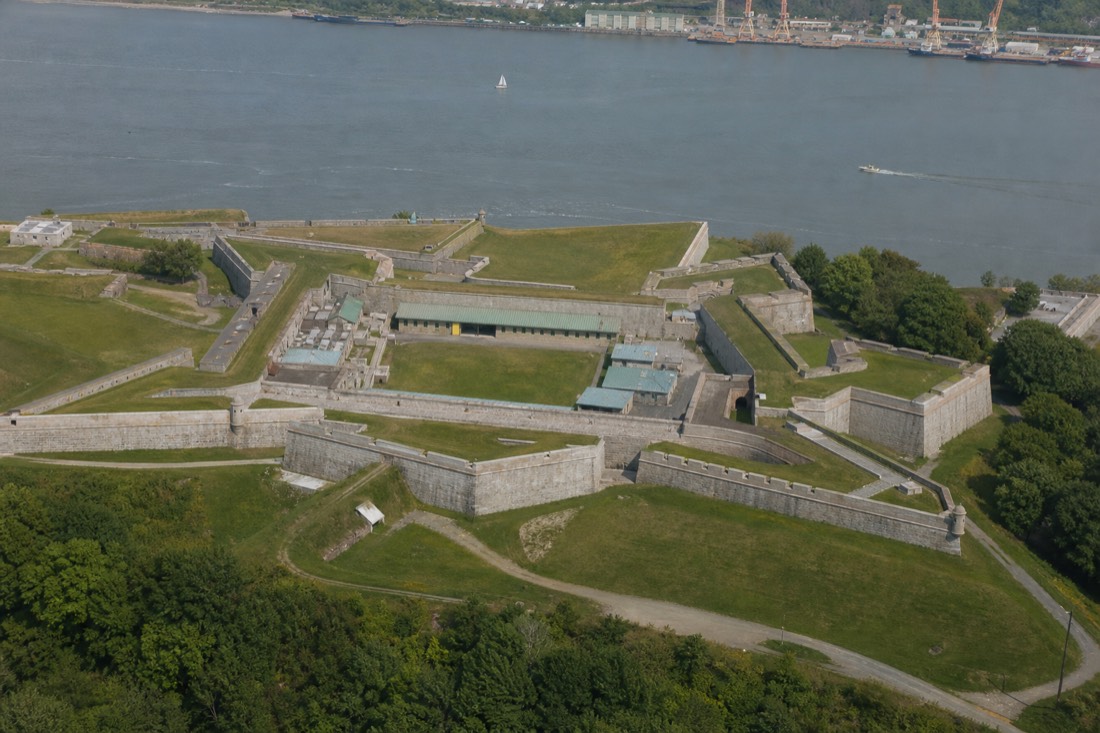Aerial angle on the star-shaped bastions and grassy ramparts of the Citadelle of Quebec above the St. Lawrence