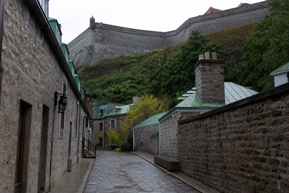 Guided walking tour group on a cobbled Old Quebec street below the Citadelle fortifications