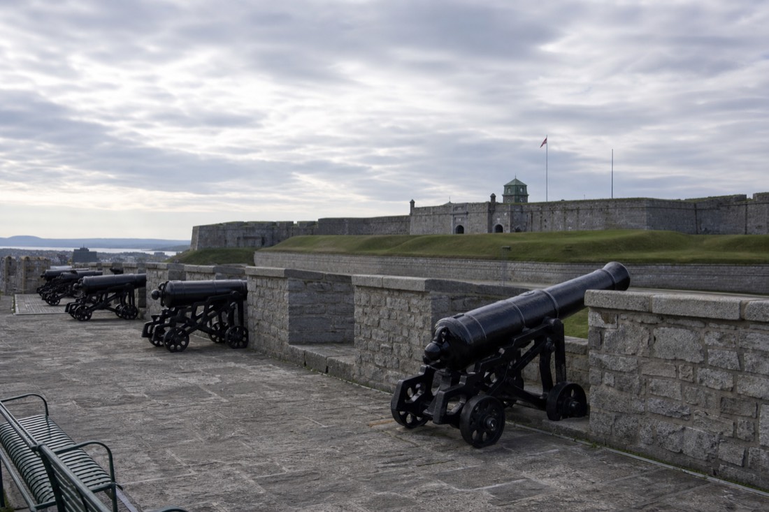 Cannons lining the rampart walkway of the Old Quebec city walls with the Citadelle beyond