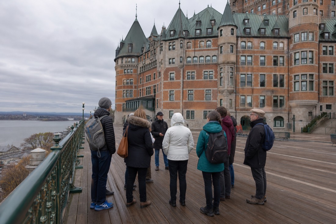 A small guided walking group gathered on the Dufferin Terrace boardwalk beside the Château Frontenac