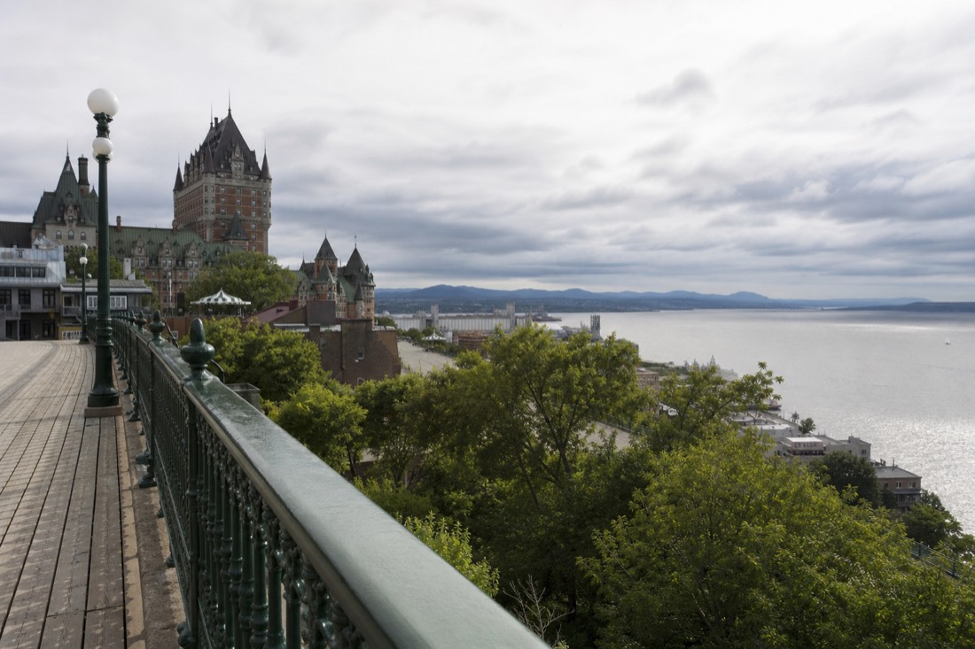 Visitors leaning on the railing of the Dufferin Terrace boardwalk looking out over the St. Lawrence River