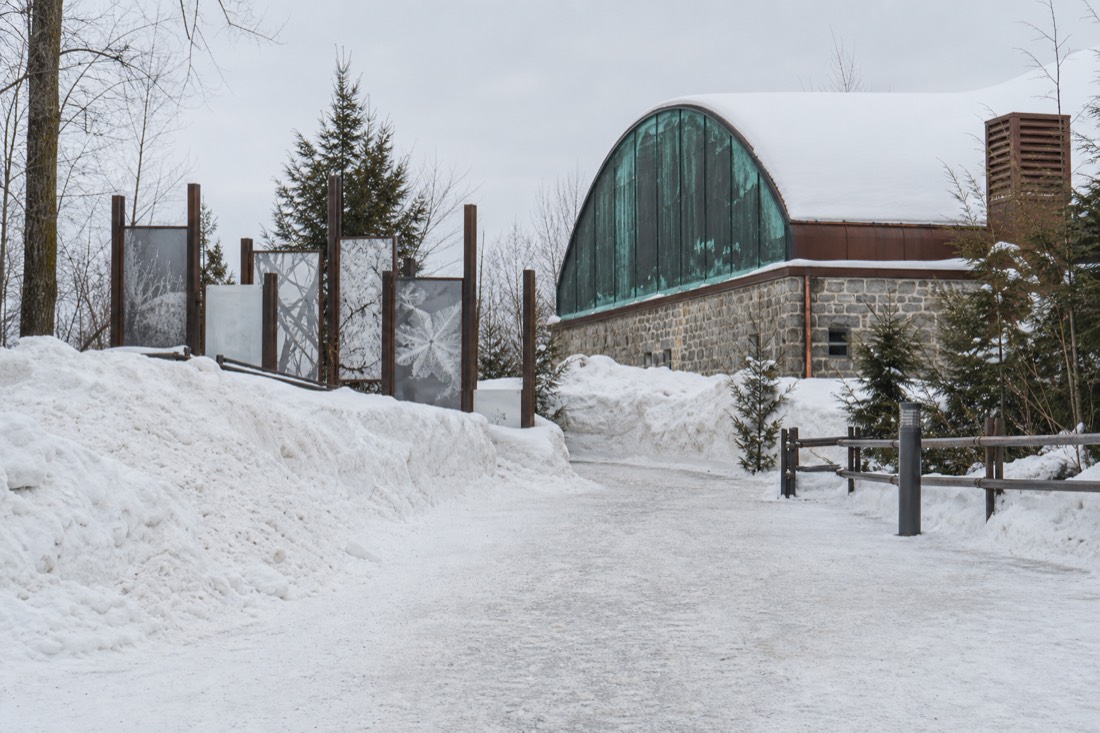 Snow-covered approach path and season signage at the Hôtel de Glace near Quebec City in January