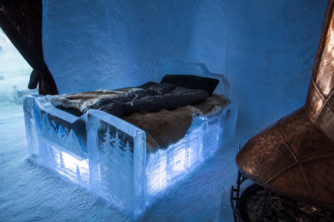 Ice bed with furs and a winter sleeping bag inside a themed suite at the Hôtel de Glace near Quebec City