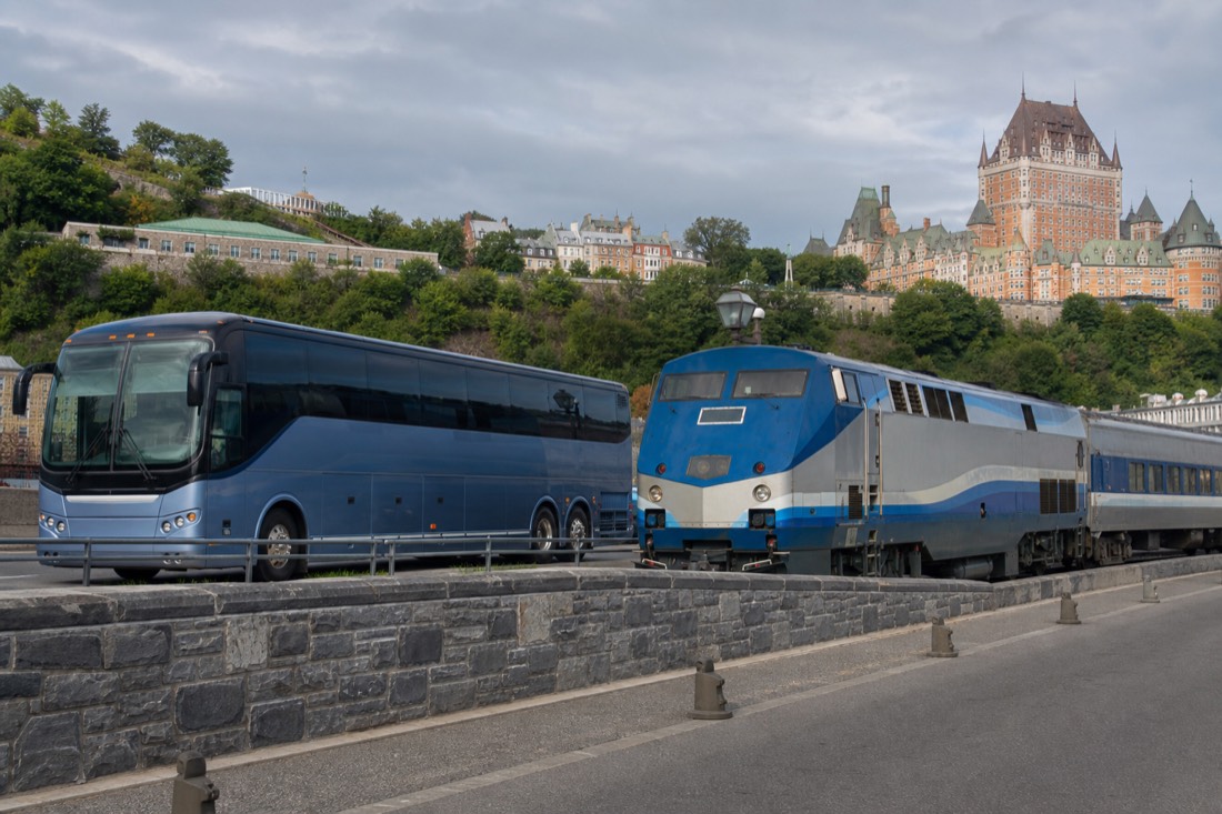 Coach bus and passenger train side by side representing Montreal to Quebec City travel options