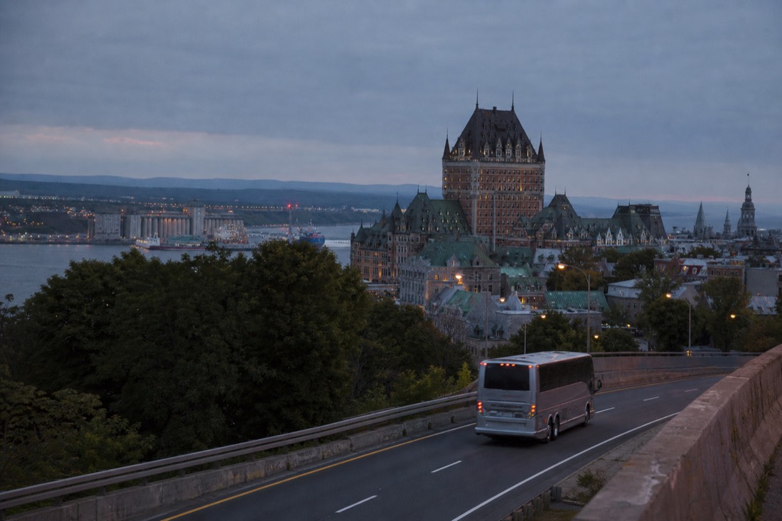 Intercity coach arriving in Quebec City on a highway approach at dusk