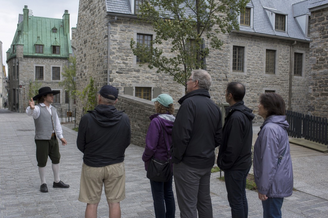 Guide leading a small group past stone facades on a Quebec City walking tour