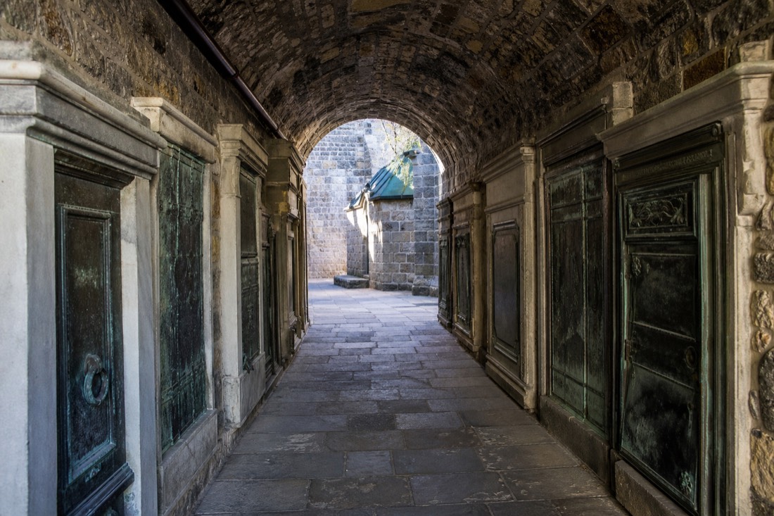 Vaulted stone crypt passage beneath a historic Quebec City church lined with old burial vaults
