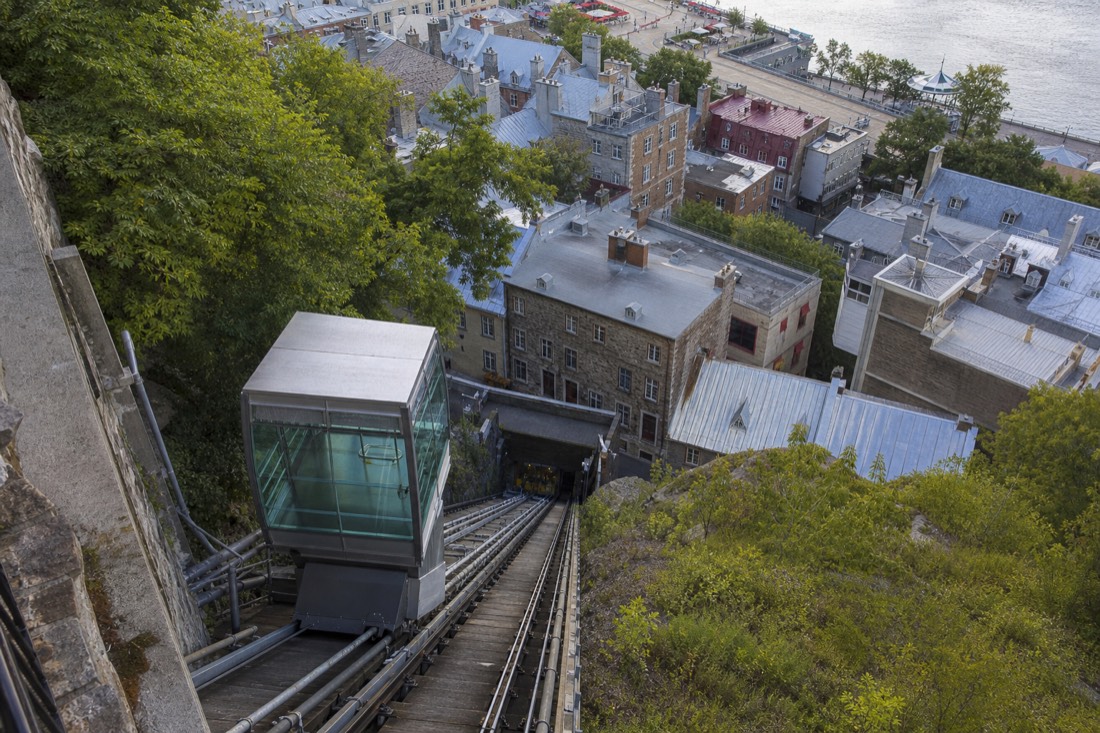 The Old Quebec funicular glass car descending the cliff toward the rooftops of Petit Champlain