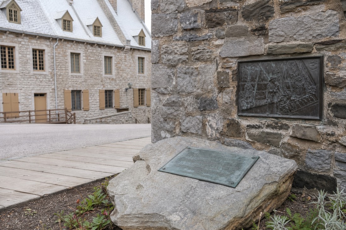 Stone plaque and old walls at Place Royale marking the site of Champlain's 1608 habitation in Quebec City