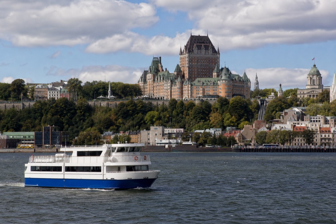 A sightseeing cruise boat on the St. Lawrence River with the Quebec City skyline behind